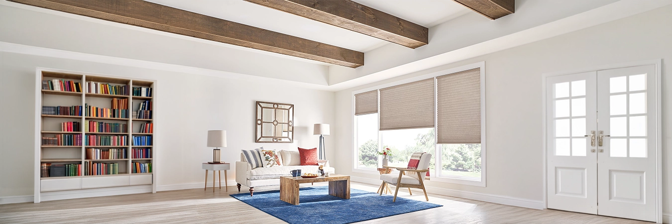 Beige motorized cellular shades on large living room windows