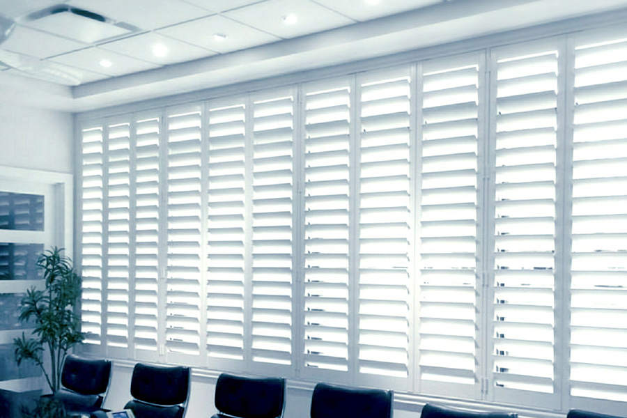 white polywood shutters on a large window in a conference room