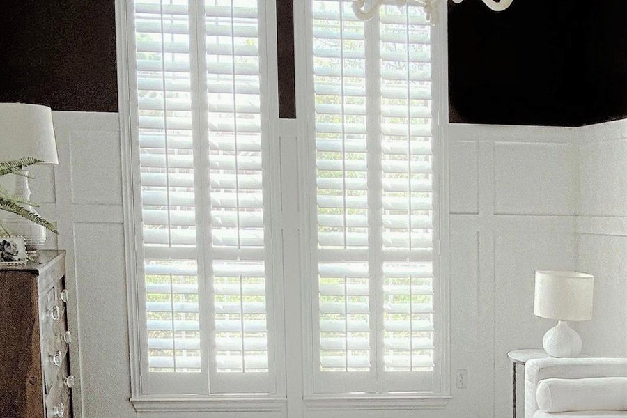 Polywood shutters give your long windows more energy efficiency. Photo Credit: @ nifty.nest
White and black sleek living room with long white polywood shutters